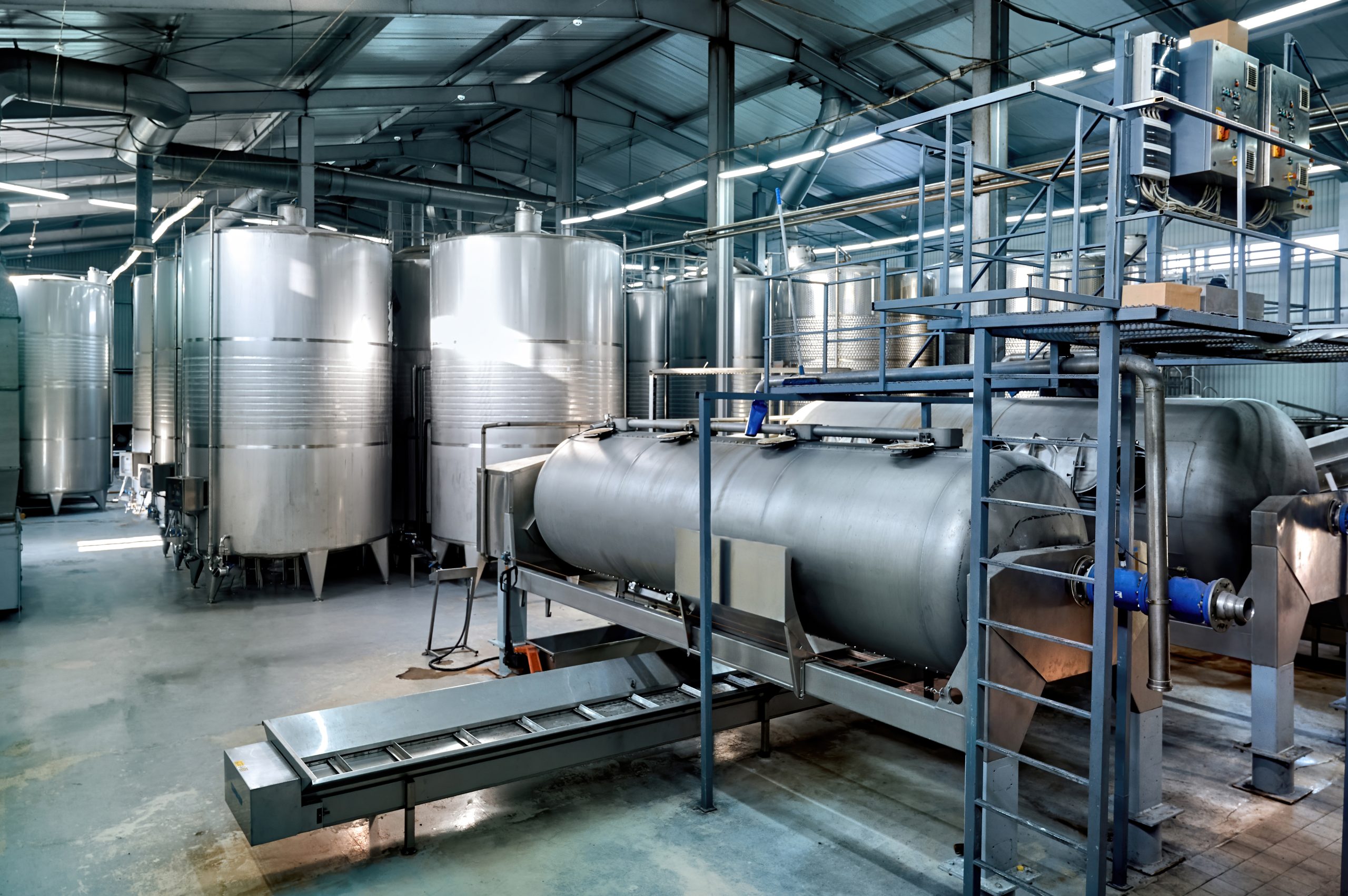 Metal wine storage tanks in a winery. Wide shot